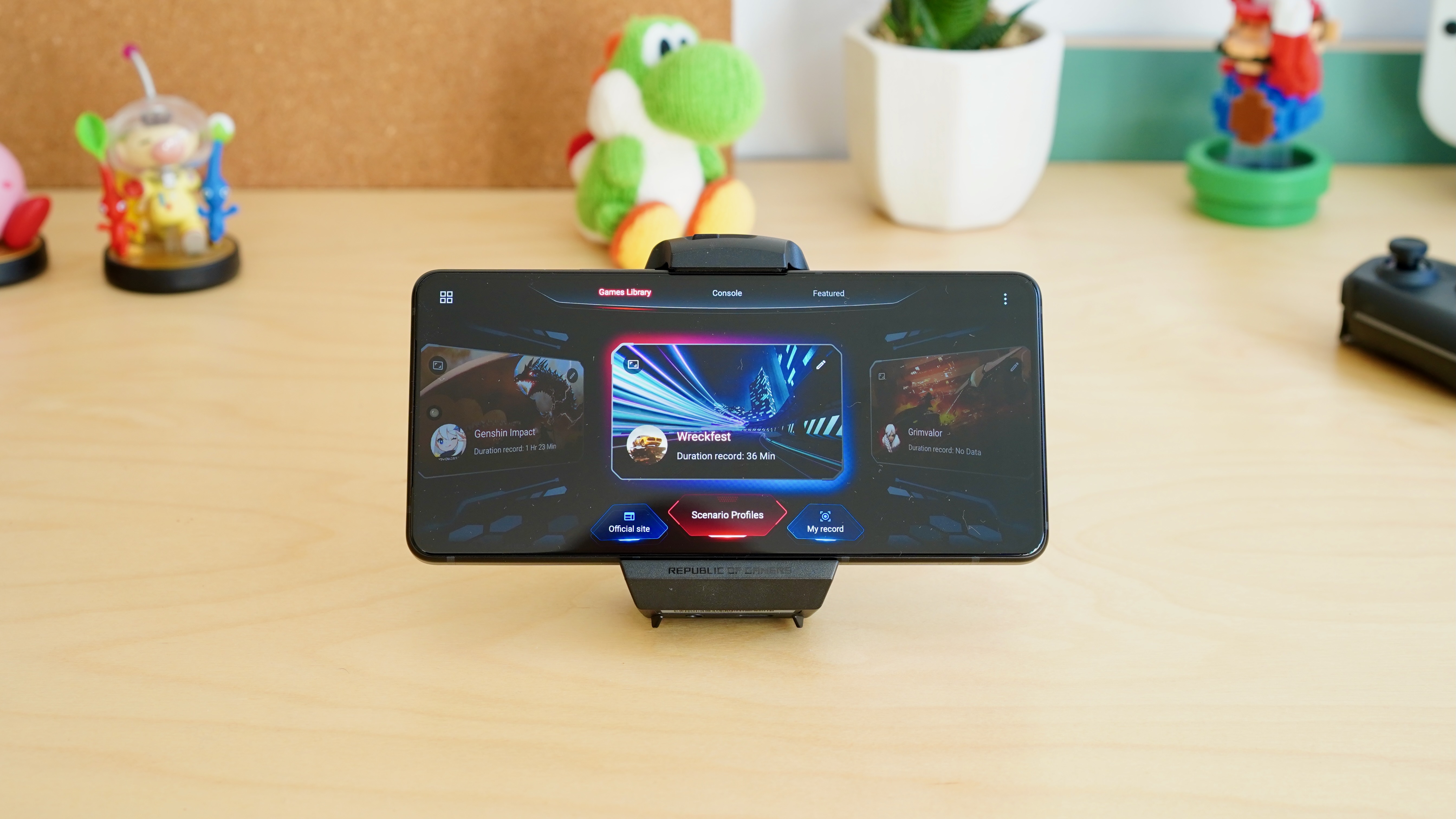 Black smartphone held horizontally on a stand, showing a dedicated gaming menu